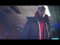 a man in a red jacket standing in a hallway
